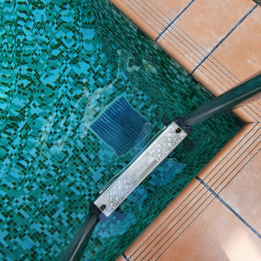 The Importance of Your Pool’s Water Levels. A picture showing a corner of the pool with the pool ladder, filter, skimmer, and drainage to facilitate the importance of pool water levels.