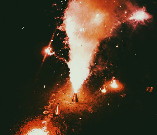 Independence Is Readiness: Why Fire Preparedness Is The Most Patriotic Act This Fourth of July. A picture showing fireworks with sparks coming out of it in the wilderness in the dark with dry fields around.