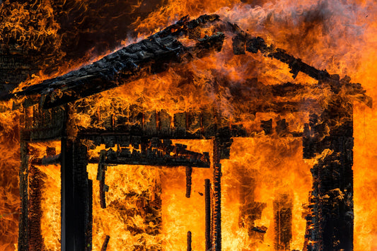 Burning Reality: Why Firefighter Shortages Demand Homeowner Action. A wooden structure fully on fire burning away under a huge house fire.
