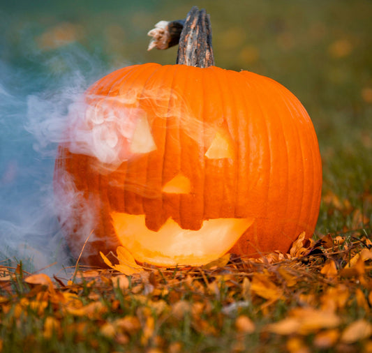 Trick, Treat, or… Torch? Why October Is Hotter Than You Think. A picture of a jack-o'-lantern pumpkin lit on the inside slowly burning with smoke rising.